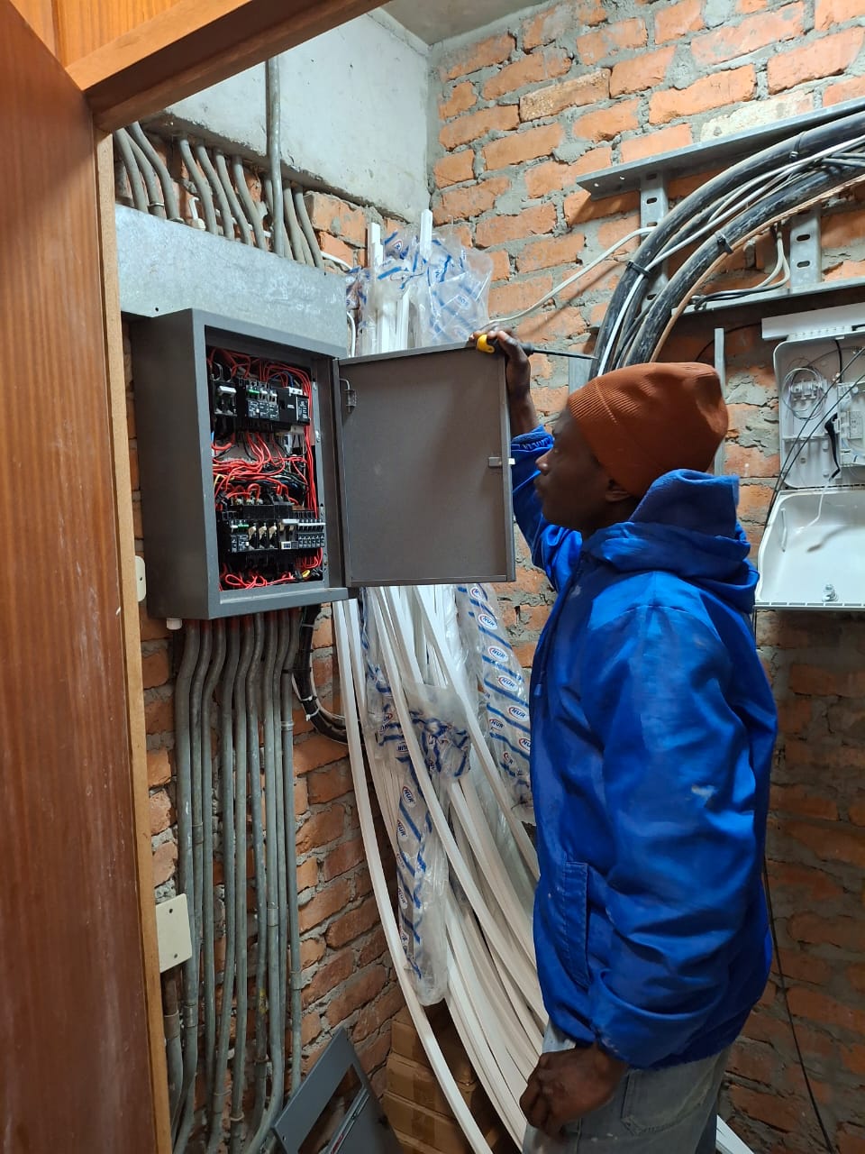 TSH Home Services electrician working inside a wall-mounted control panel during a first-fix installation
