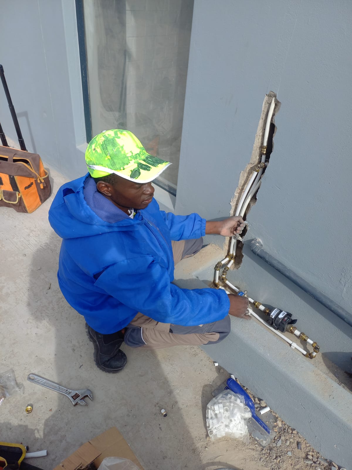 TSH Home Services plumber fitting pipework and a water meter into a chased exterior wall