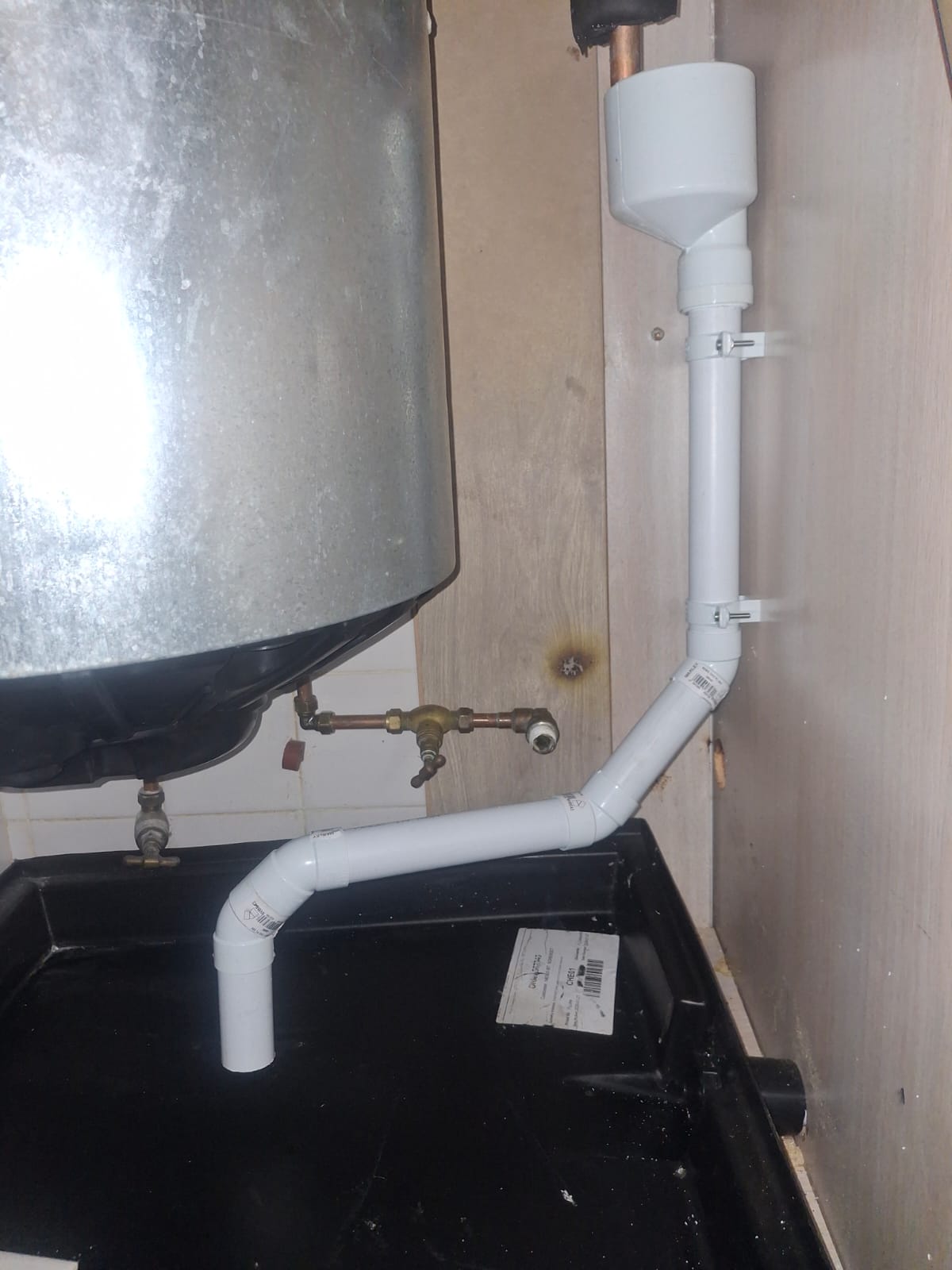 Geyser installation with drip tray, overflow tray outlet and PVC discharge pipework